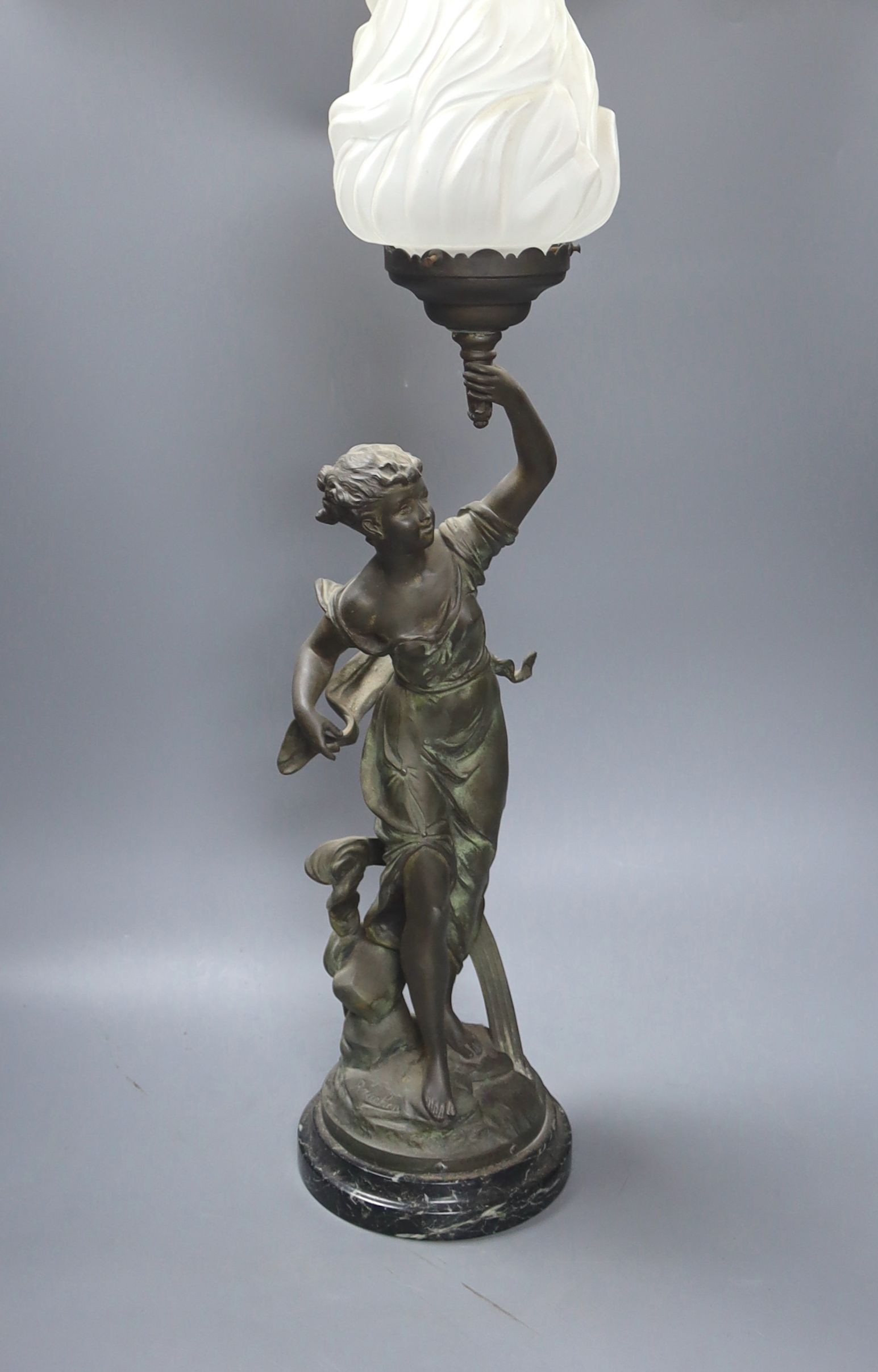 An Art Nouveau spelter figural flame shaded table lamp,74 cms high.